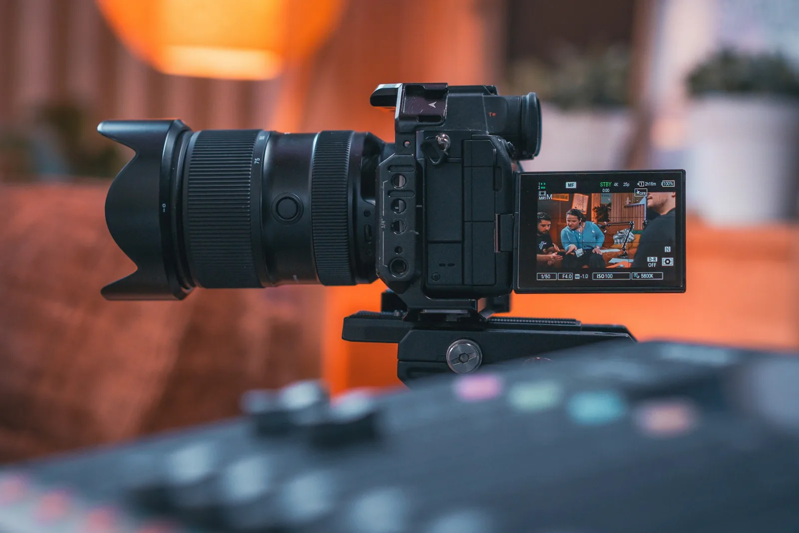 Professional camera on a tripod with its recording monitor open
